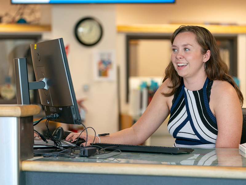 A staff member behind a computer