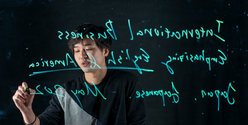 Person drawing on a see through board with blue ink