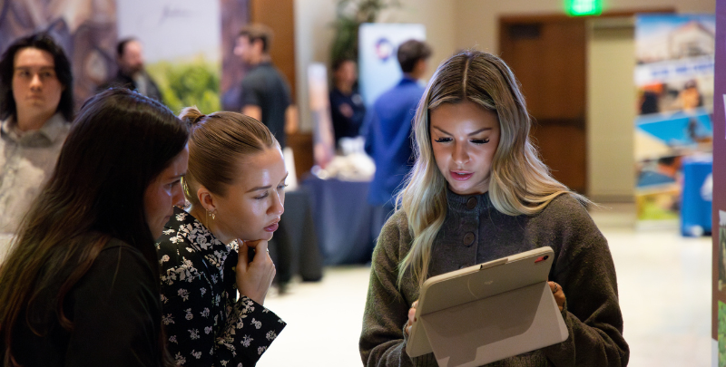 3 girls looking at a tablet.