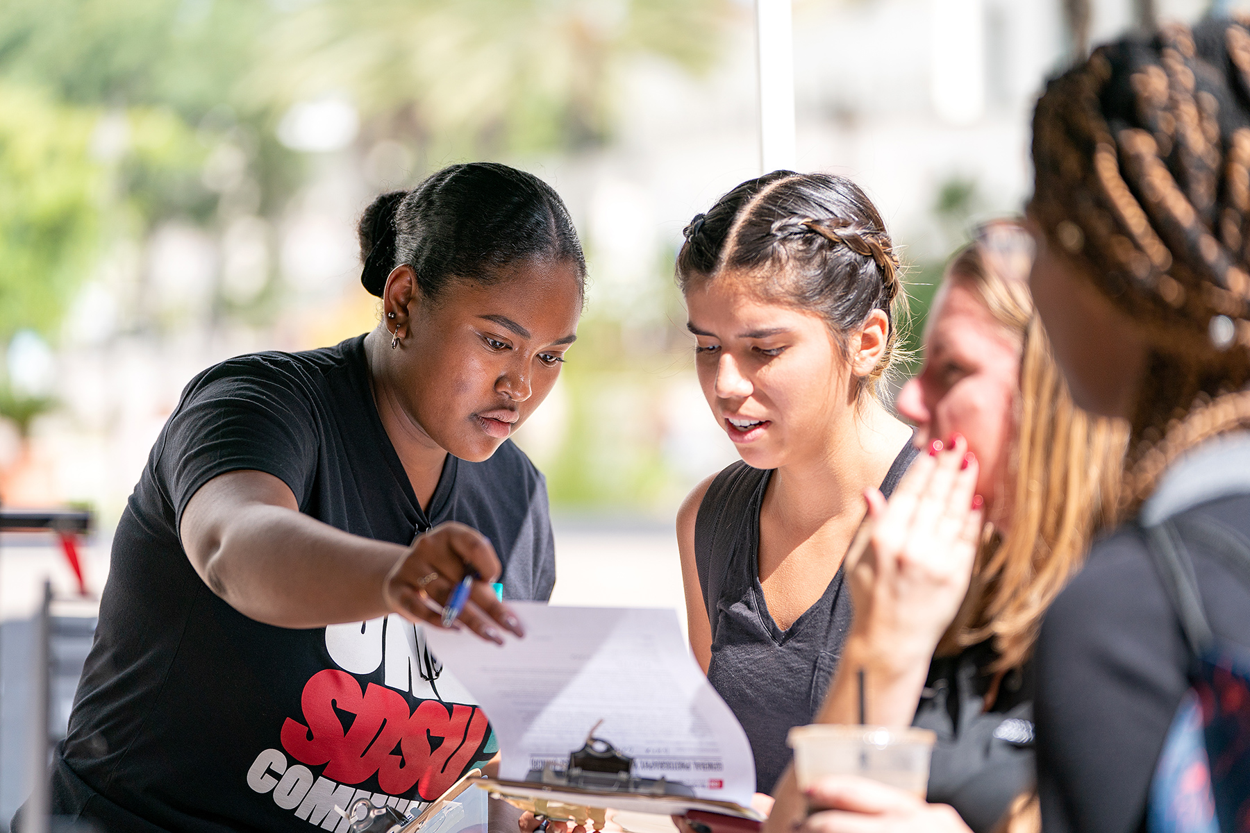 Students getting information at the One SDSU Community table.